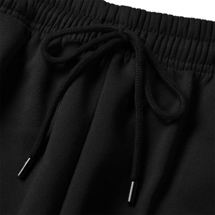 Close-up of 250G black jogger pants elastic waistband with black adjustable drawstring and metal tips