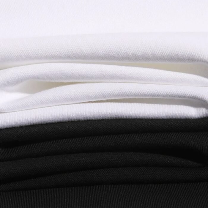 Stacked White and Black T-shirt Fabric - Close-up of Soft, Breathable Material