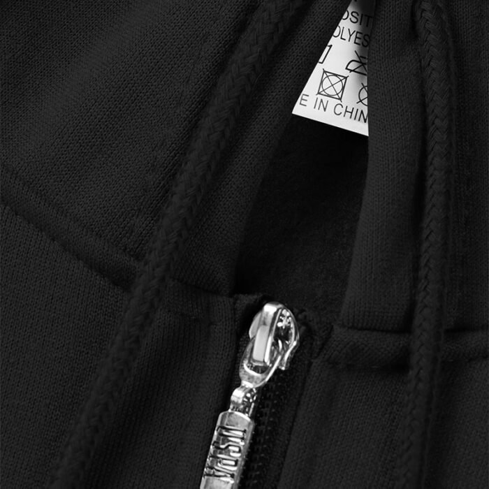 Extreme close-up of the silver zipper pull and black drawstring of a black zip-up hooded sweatshirt.